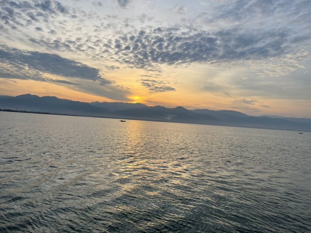 There is a special moment in Burundi that many visitors never get to see.
A moment when the city is quiet…
The lake is calm…
And nature gently wakes up with golden light.
Our Tanganyika Early Morning Tour gives you front-row access to this magic.
It’s not just a tour — it is an experience that touches your soul.
✨ A Peaceful Start to Your Day
Before the city comes alive, Lake Tanganyika whispers with soft waves and cool morning air. As you arrive at the lakeshore, you feel the calmness of a new day beginning.
The sky slowly shifts from deep blue to orange and gold.
Birds glide over the water.
The mountains in the distance turn into soft silhouettes.
This is sunrise on Lake Tanganyika — one of the most beautiful scenes in East Africa.
🛶 Witness Life on the Lake
As the light becomes brighter, you’ll see the daily rhythm of Bujumbura unfold.
Local fishermen, after spending the whole night on the lake, return with their morning catch.
Their traditional boats glide on the still water.
You experience their lifestyle up close — simple, real, and deeply connected to the lake.
This is the moment where:
You see the beauty of the city waking up
You watch the sun rising over the world’s second deepest lake
You experience people fishing and living their morning traditions
It is authentic, pure Burundian life — not a show, not staged, just reality at its finest.
📸 A Dream for Photography Lovers
Early morning light is the most beautiful for photos.
During the tour, you will capture:
The golden sunrise over the lake
Fishermen balancing on wooden boats
Reflections of the city on calm water
Silhouettes of mountains and palm trees
Every photo becomes a memory you’ll want to frame.
📍 Tour Program
Time Activity
05:30 Pickup from your hotel
05:50 Arrival at the lakeshore and boat departure
06:00–06:40 Enjoy sunrise, take photos, relax on the water
06:40–07:00 Observe fishermen returning with their morning catch
07:00–07:20 Optional stop at a lakeside beach for coffee or tea
07:30 Return to shore and drop-off at your hotel
💵 What’s Included
Private boat
Professional guide
Hotel pickup and drop-off
Drinking water
Optional: coffee or tea at the beach.
🌟 Why Travelers Love This Tour
It’s calm, peaceful, and perfect for starting your day
You experience authentic local life
The sunrise views are unique and unforgettable
It’s short — perfect before another activity
Many travelers say this is one of the best experiences in Bujumbura.
🚤 Experience Lake Tanganyika With M Travel and Tours Burundi
We know this lake better than anyone.
We grew up beside it.
We love it.
And we want you to feel its magic too.
Start your day with beauty, peace, and an unforgettable sunrise — only on the Tanganyika Early Morning Tour.